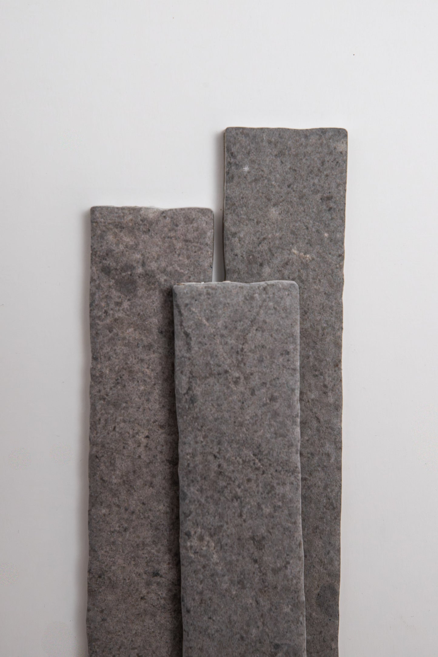 Three Toba Basilica R11 rectangular gray stone tiles stand vertically on a plain white background.