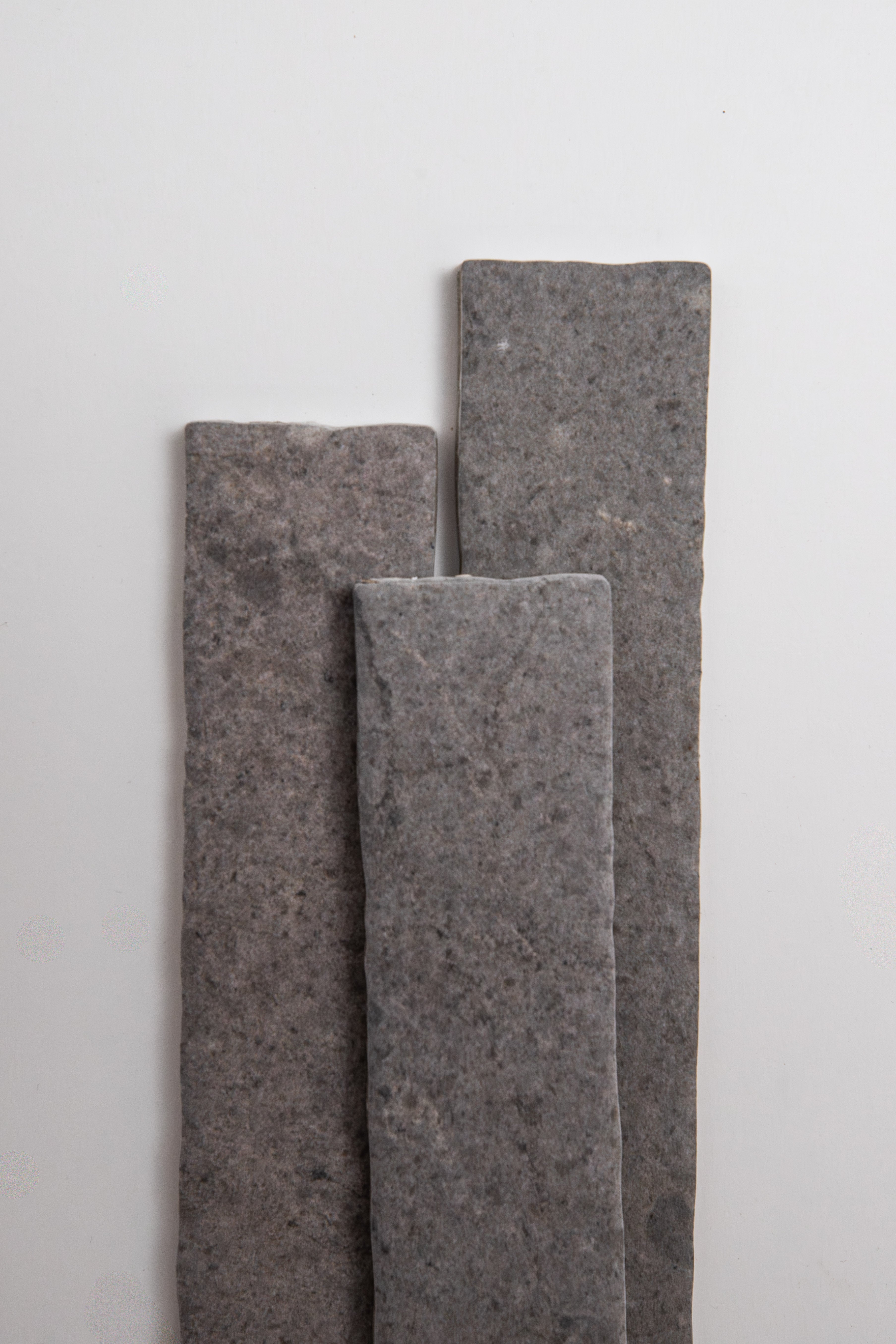 Three Toba Basilica R11 rectangular gray stone tiles stand vertically on a plain white background.