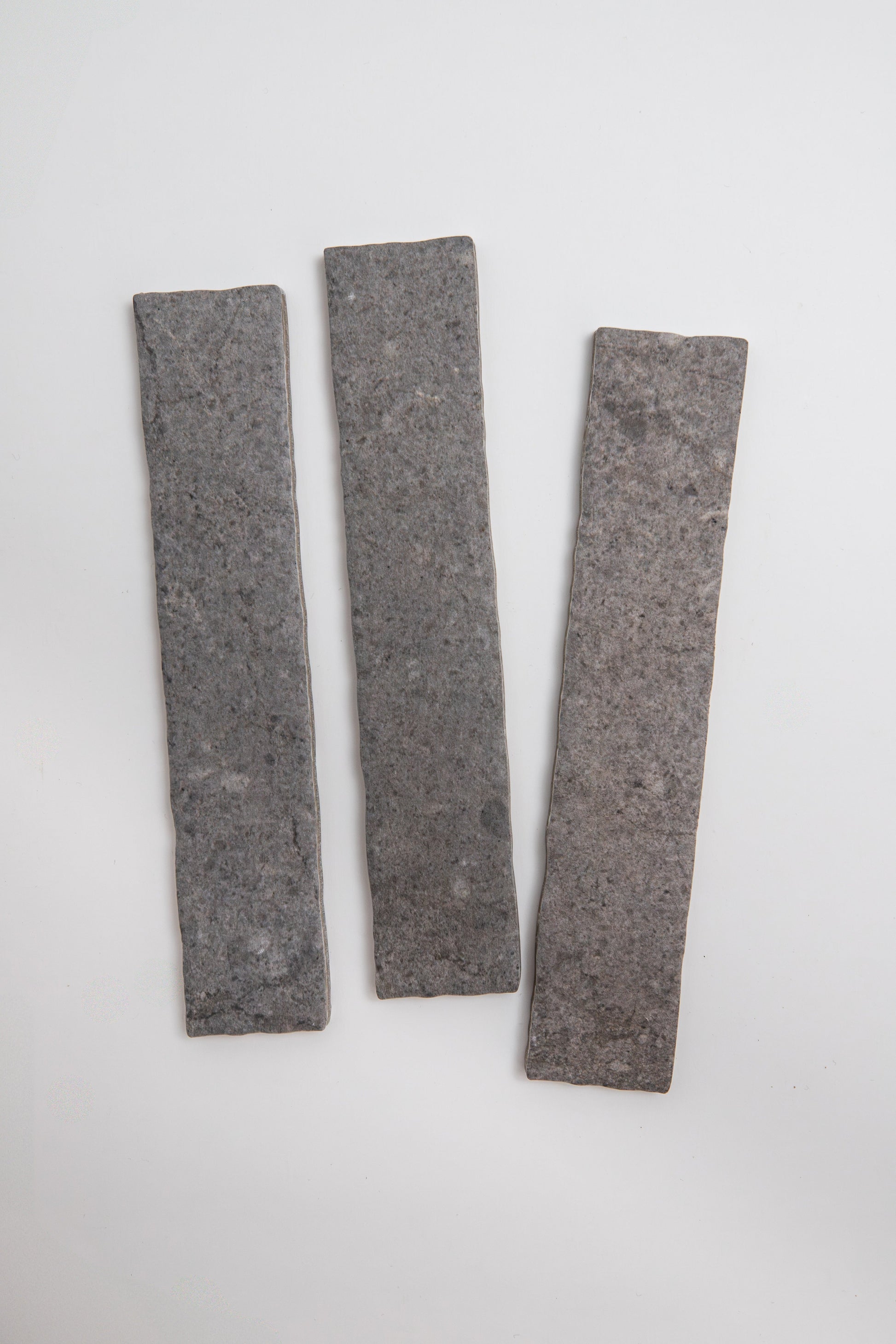 Three Toba Basilica R11 rectangular gray stone tile samples arranged vertically on a white background.