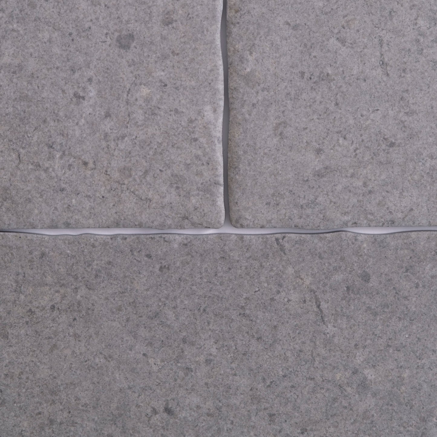 Close-up of four Toba Basilica R11 tiles by Toba, gray with visible grout lines in a cross pattern.