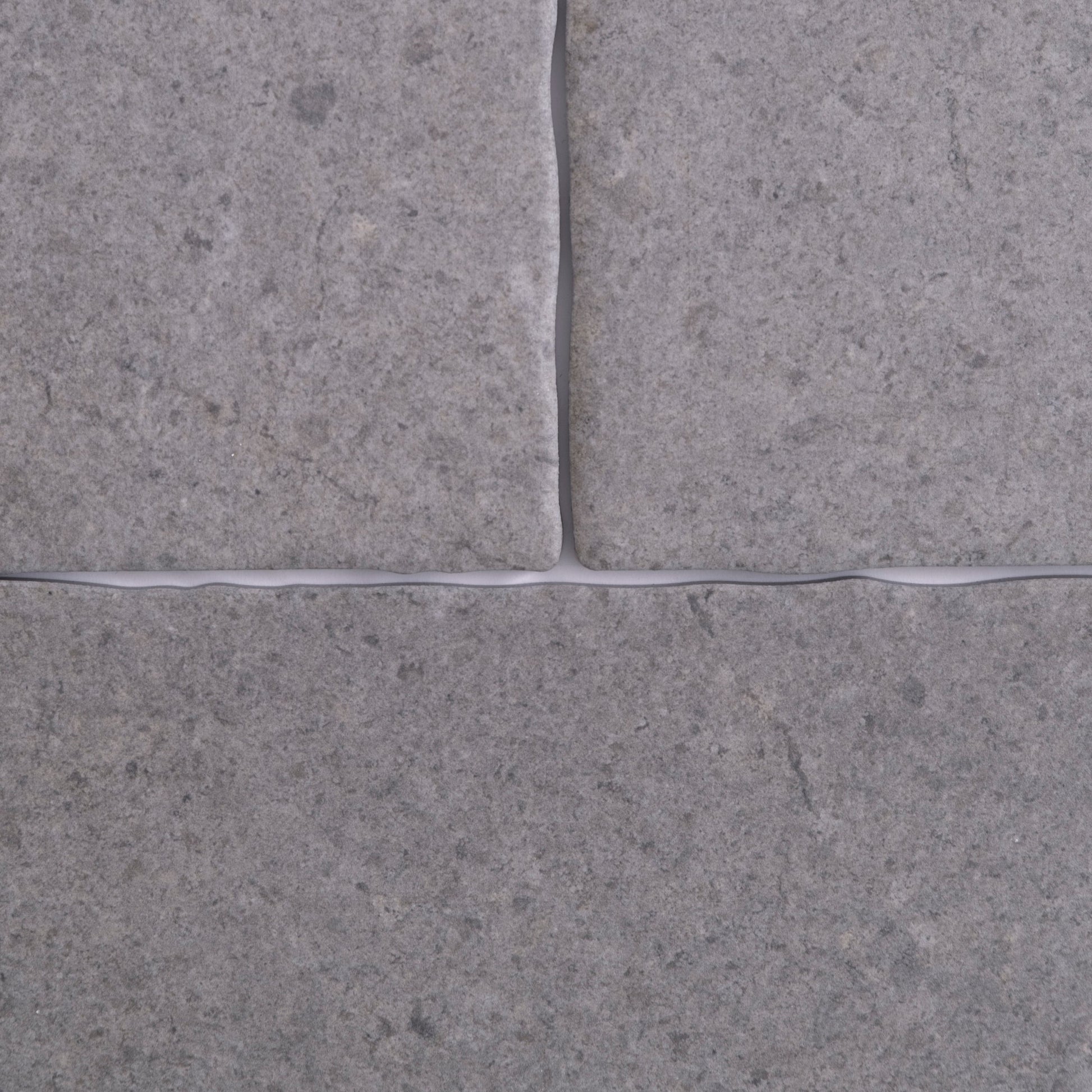 Close-up of four Toba Basilica R11 tiles by Toba, gray with visible grout lines in a cross pattern.
