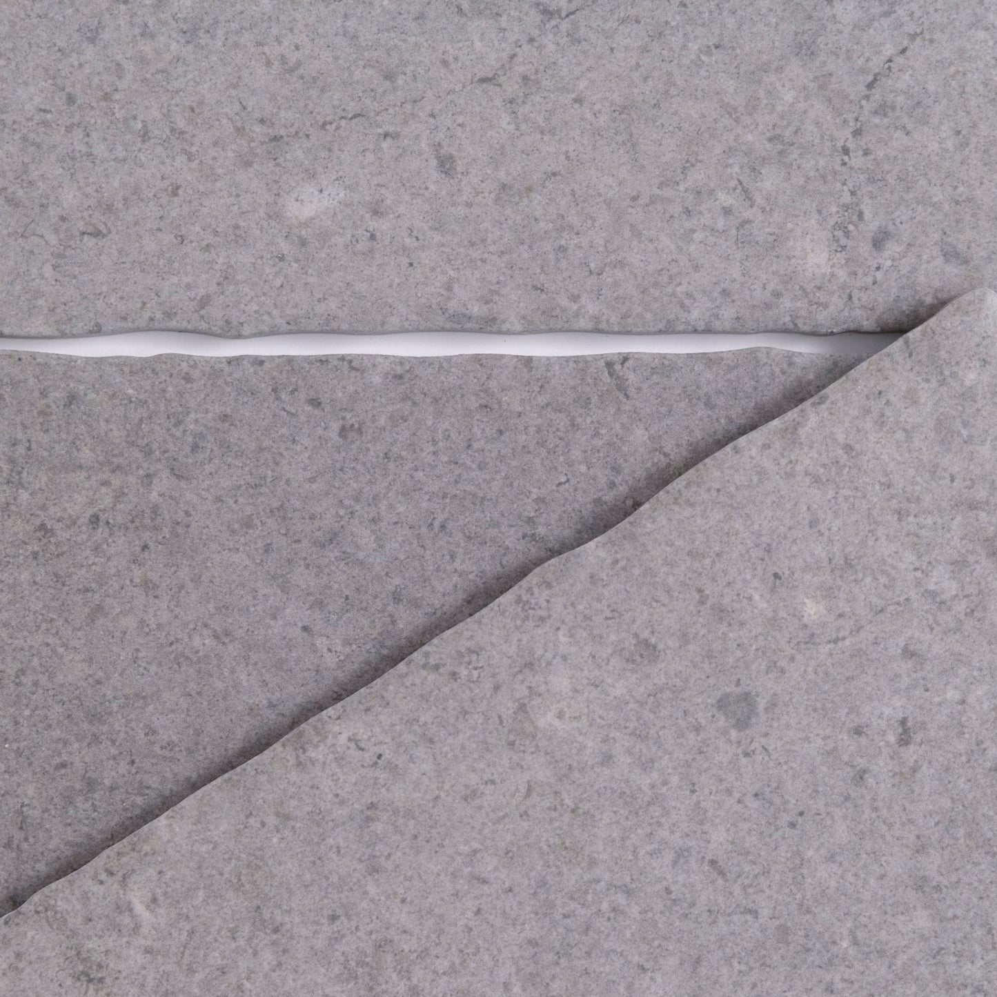 A cracked gray Toba Basilica R11, Sample surface featuring a jagged line of white filler by Toba.