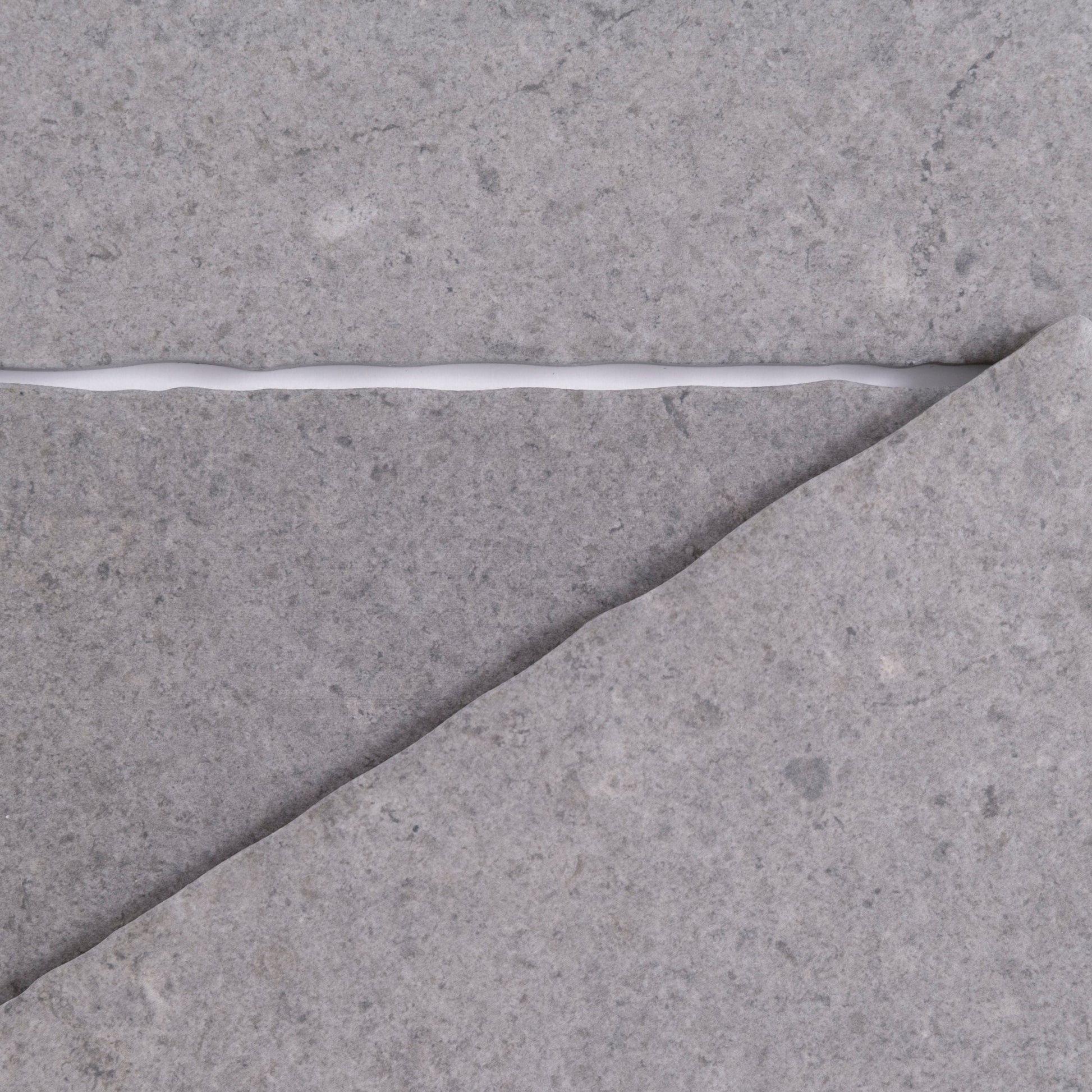 A cracked gray Toba Basilica R11, Sample surface featuring a jagged line of white filler by Toba.