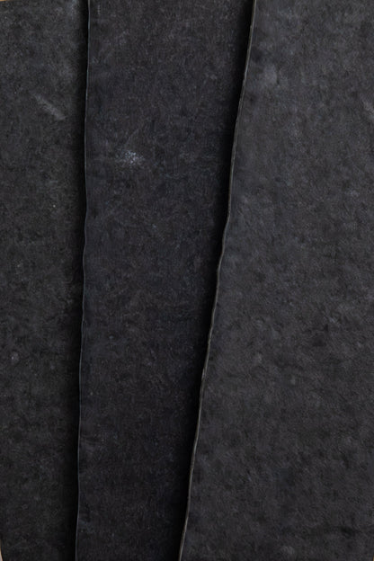 Close-up of three overlapping Toba Black R11 sheets by Toba, showing rough textures and uneven edges.
