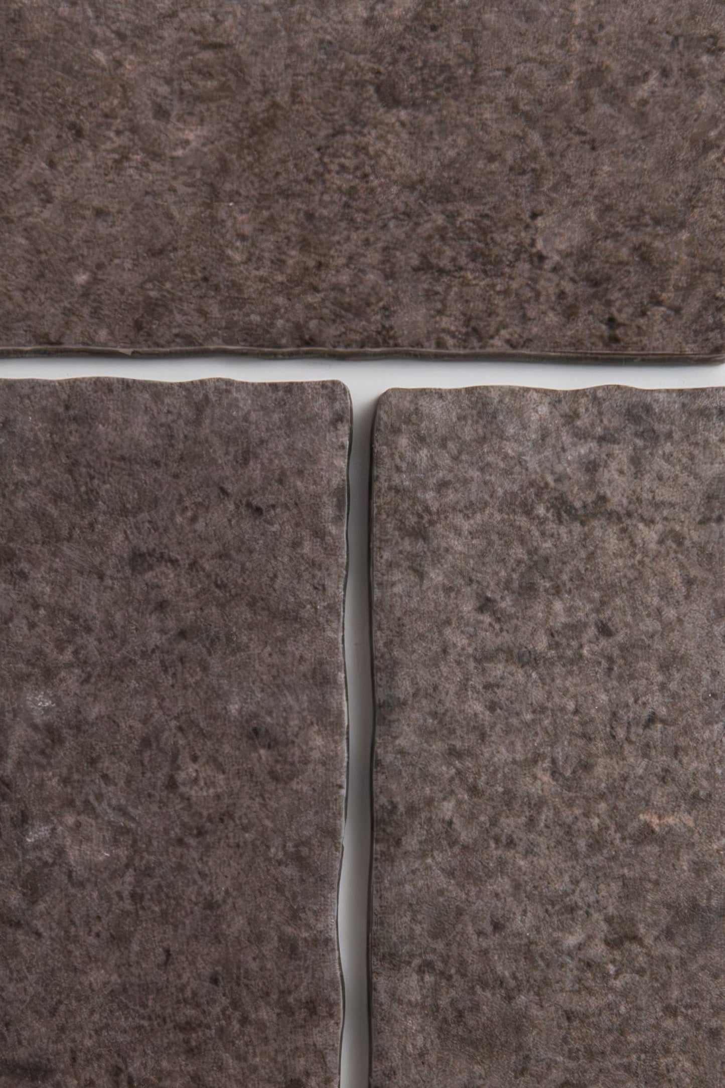 Close-up of four Toba Brun R11 tiles by Toba, showcasing dark brown color and visible grout lines.