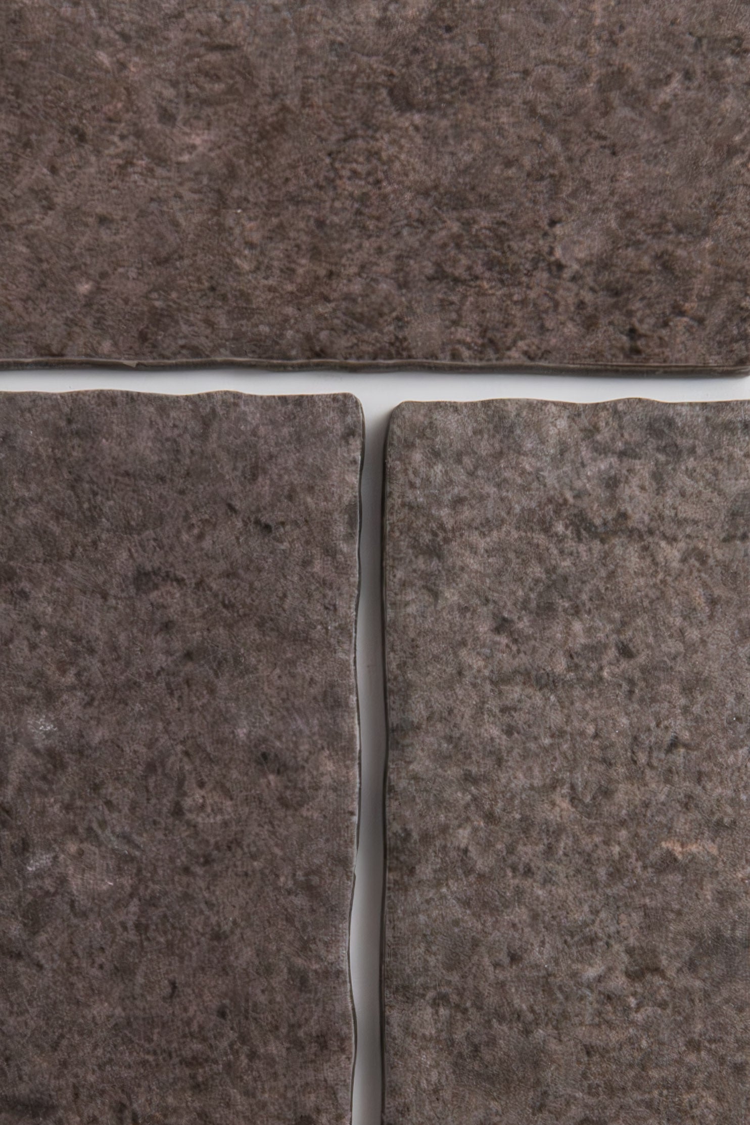 Close-up of four Toba Brun R11 tiles by Toba, showcasing dark brown color and visible grout lines.