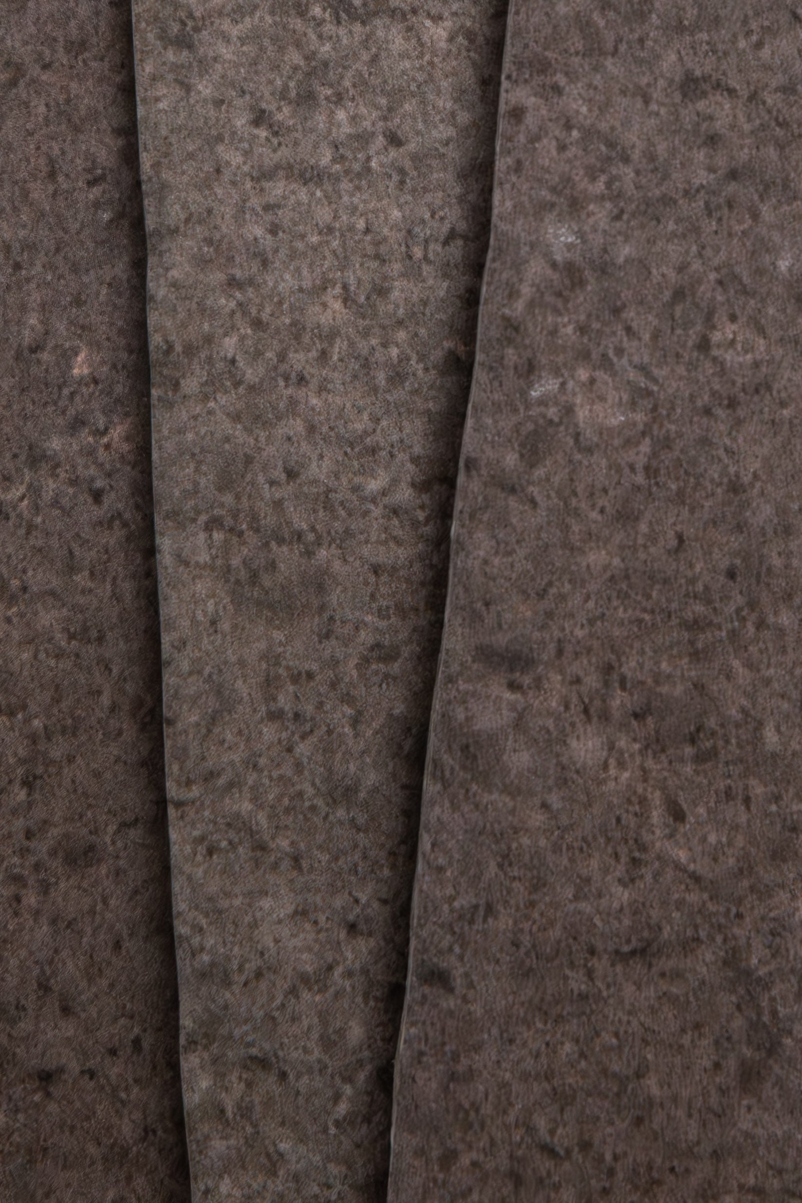 Close-up of three overlapping Toba Brun R11, Sample sheets by Toba, featuring a dark, stone-like textured surface.