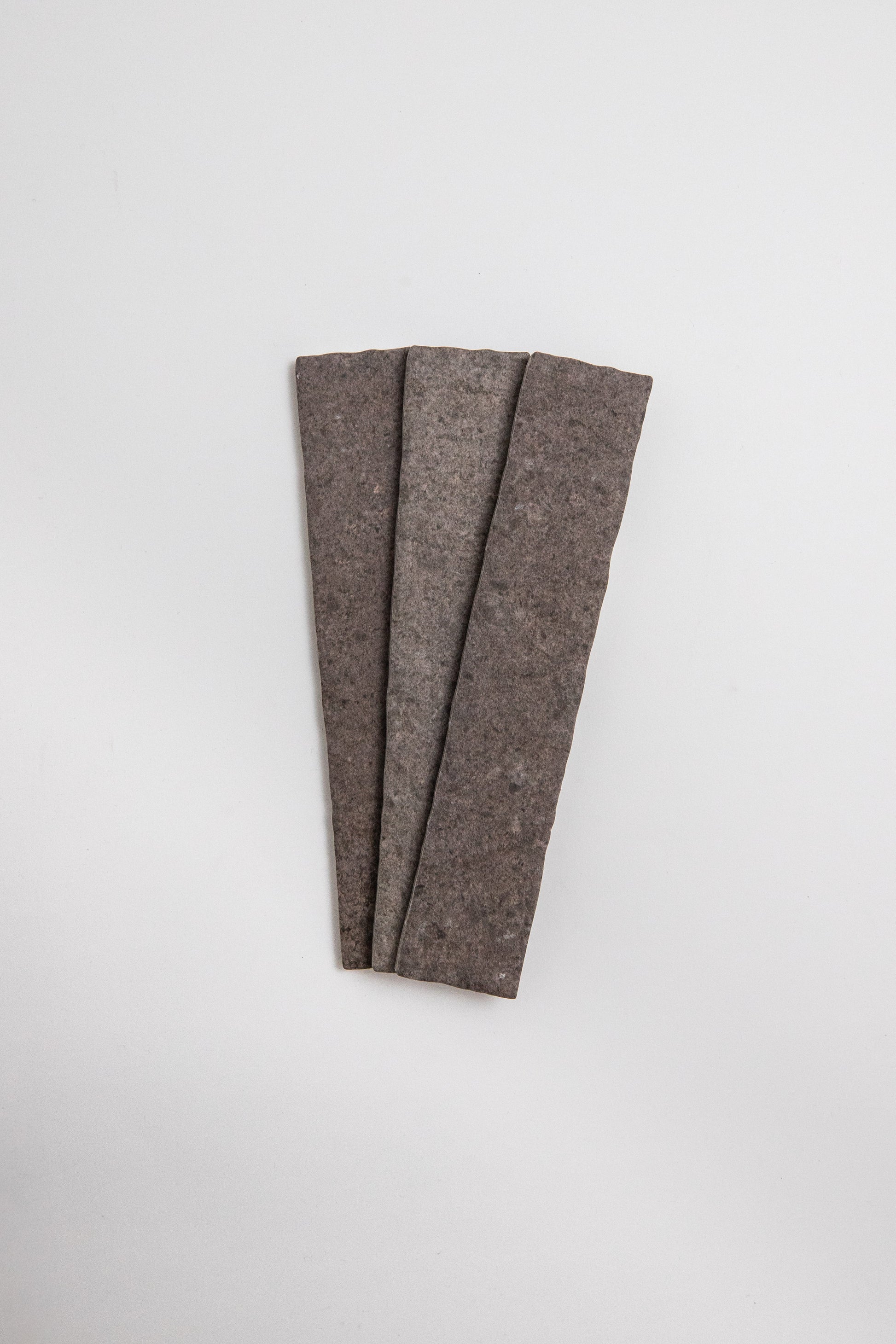 Three Toba Brun R11 crispbread crackers arranged in a fan shape on a plain white background.