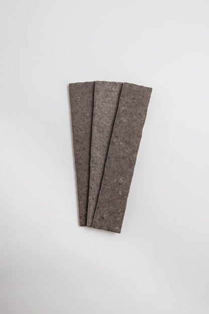 Three Toba Brun R11 crispbread crackers arranged in a fan shape on a plain white background.