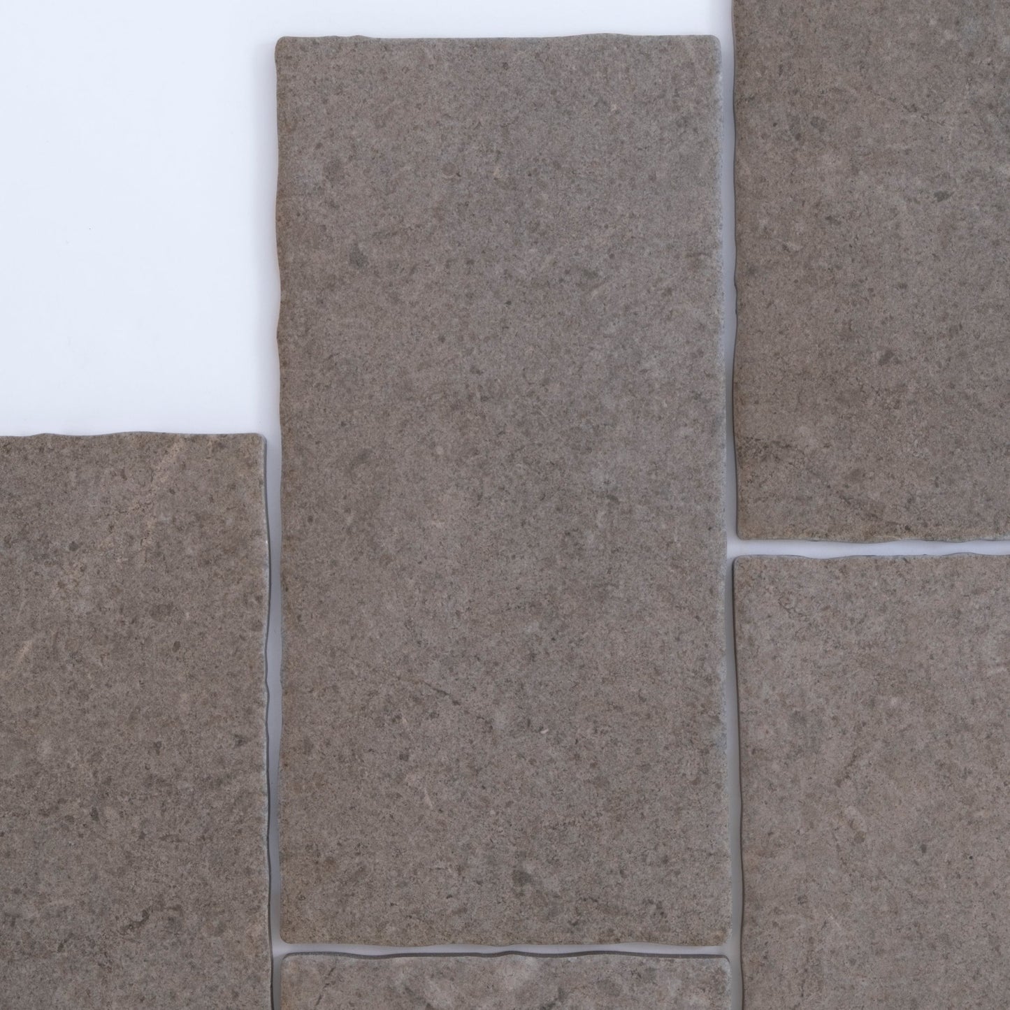 Four rectangular Toba Brun R11 sample tiles by Toba arranged closely together on a white background.