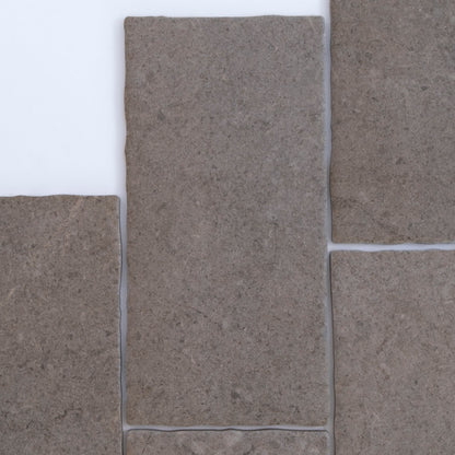 Four rectangular Toba Brun R11 sample tiles by Toba arranged closely together on a white background.