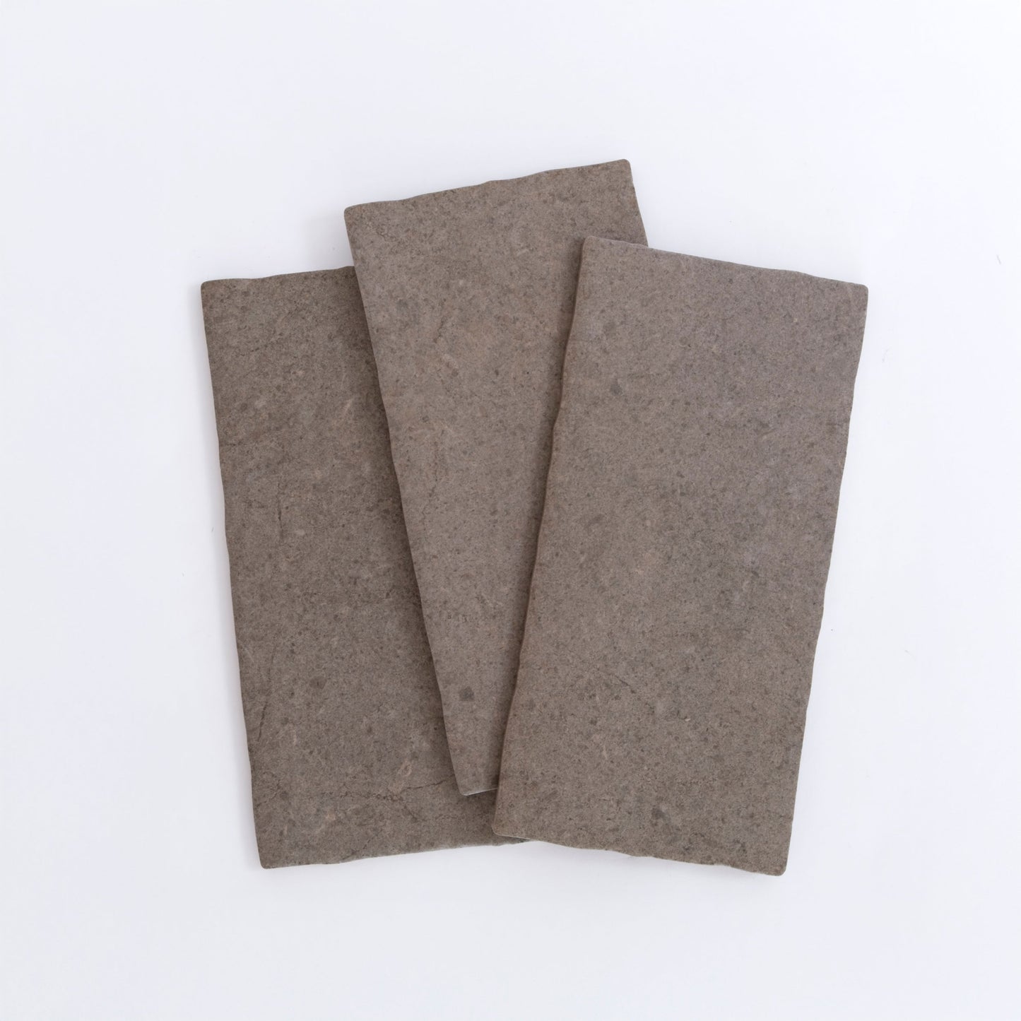 Three Toba Brun R11 sample tiles by Toba are arranged overlapping on a plain white background.