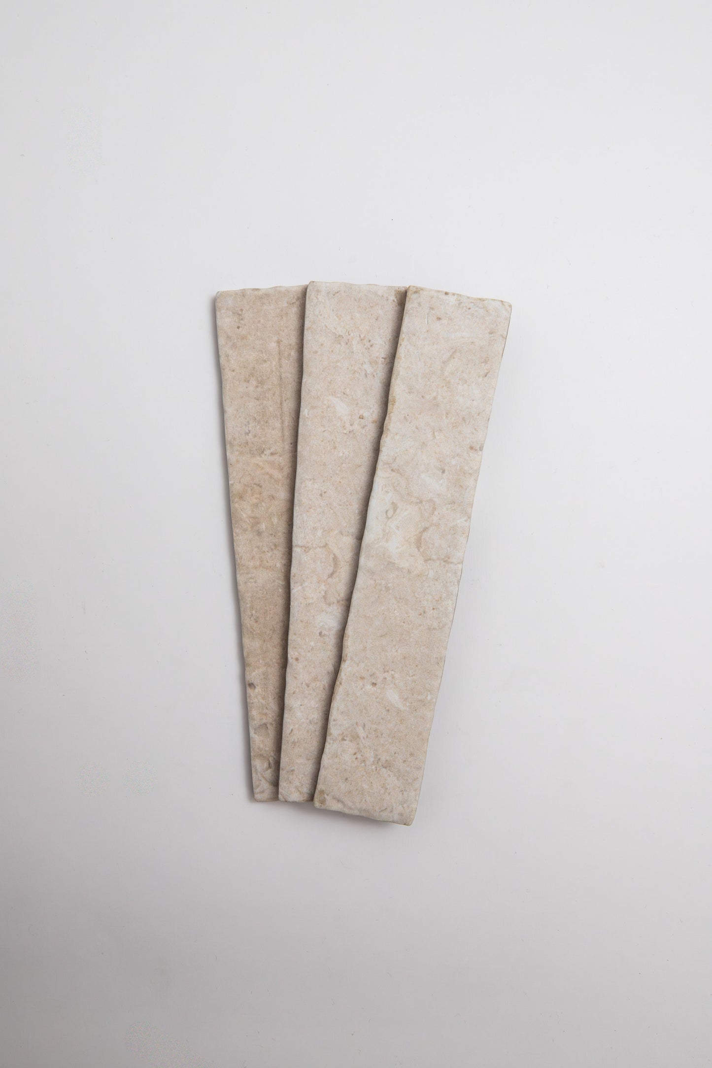 Three Toba Ivory R11 rectangular beige tiles by Toba are arranged side by side on a plain white background.