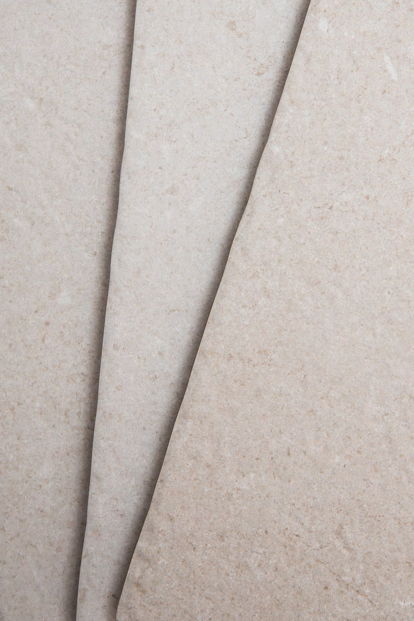 Close-up of two Toba Multicolor R11 sheets by Toba, featuring overlapping beige textured surfaces.