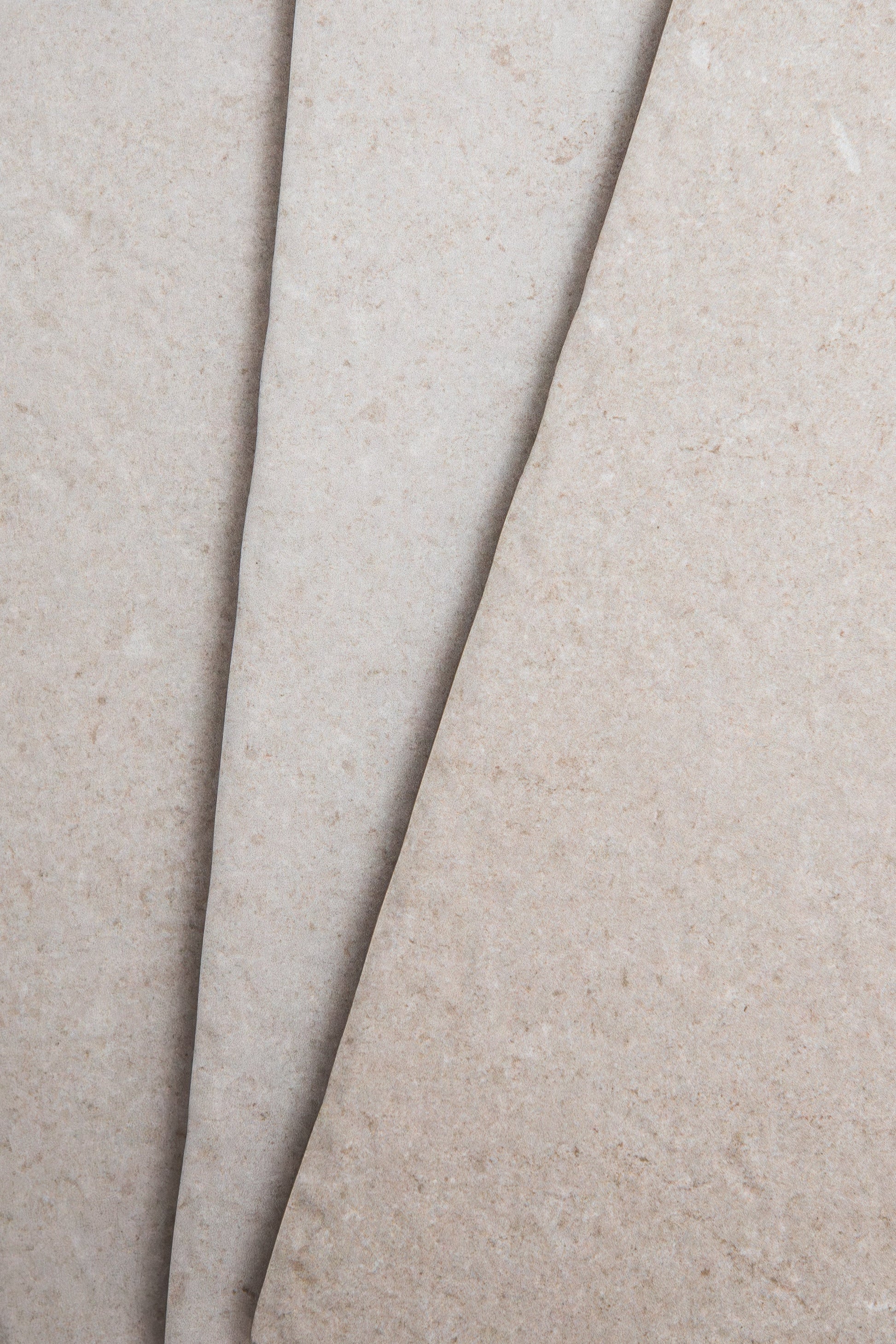 Close-up of two Toba Multicolor R11 sheets by Toba, featuring overlapping beige textured surfaces.