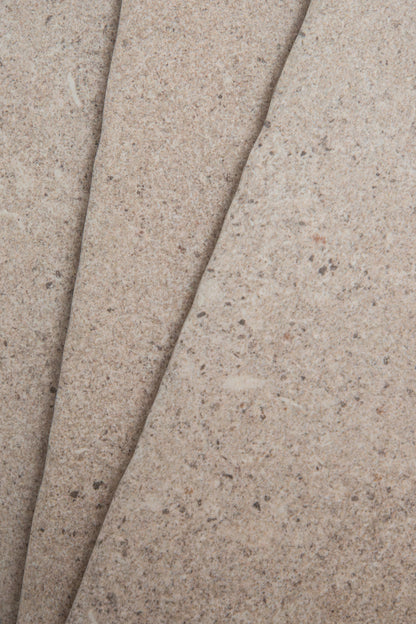 Close-up of three overlapping Toba Taupe R11 sample tiles by Toba, showing beige texture with speckles and rough surfaces.