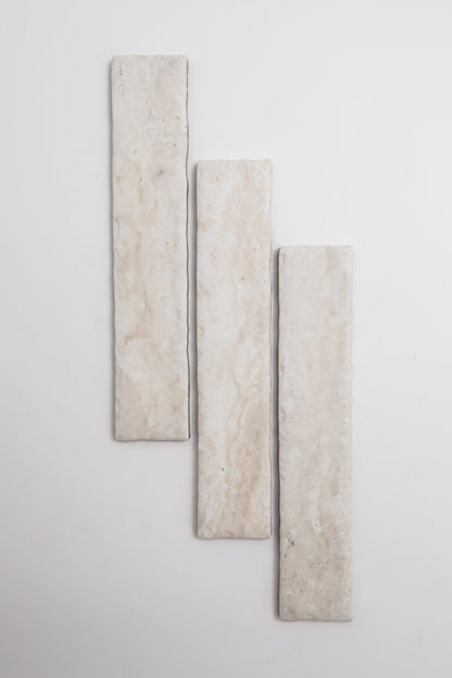 Three Tosca Travertine rectangular beige tiles arranged vertically on a white background, slightly staggered in height.