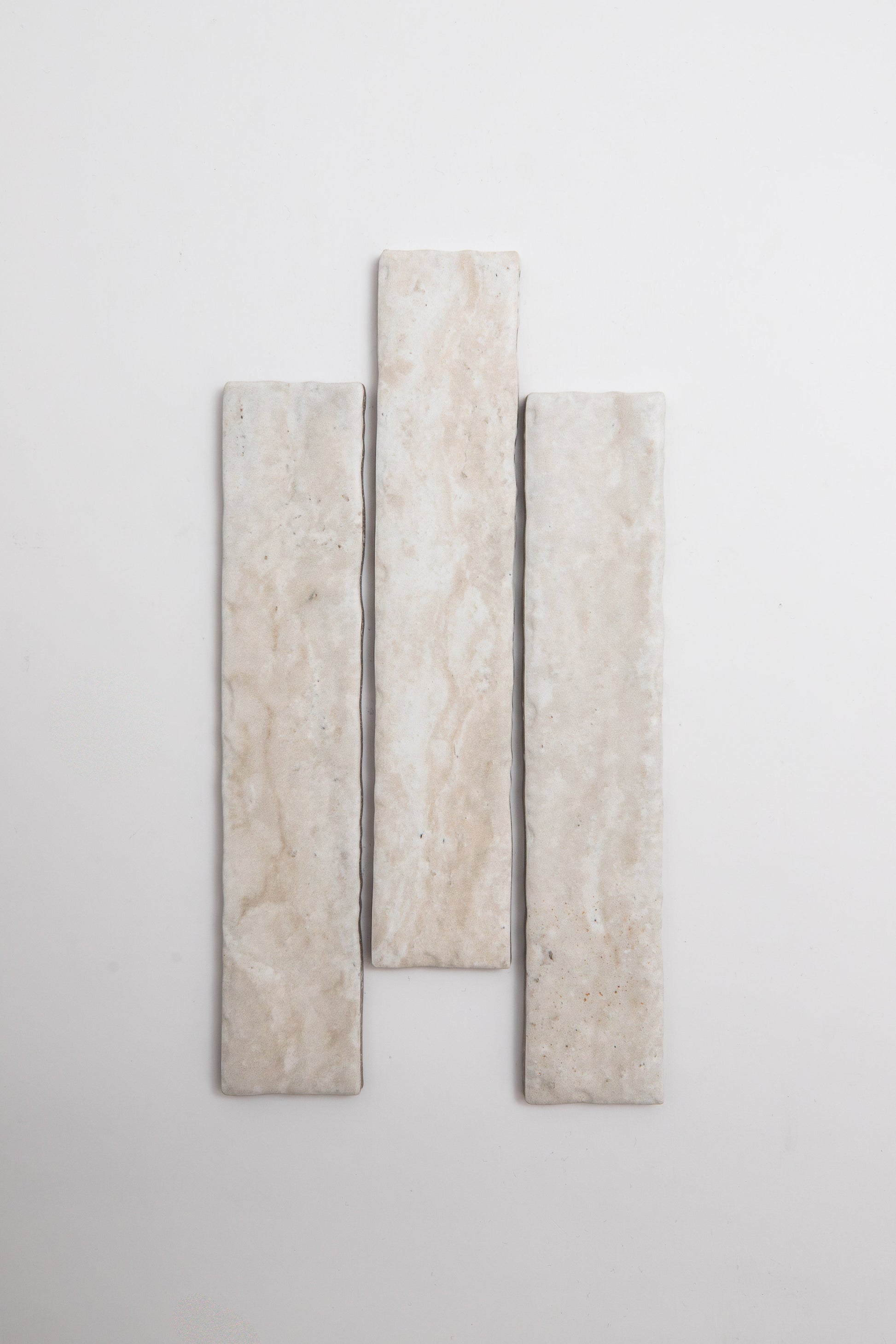 Three Tosca Travertine rectangular beige tiles arranged vertically on a plain white background.
