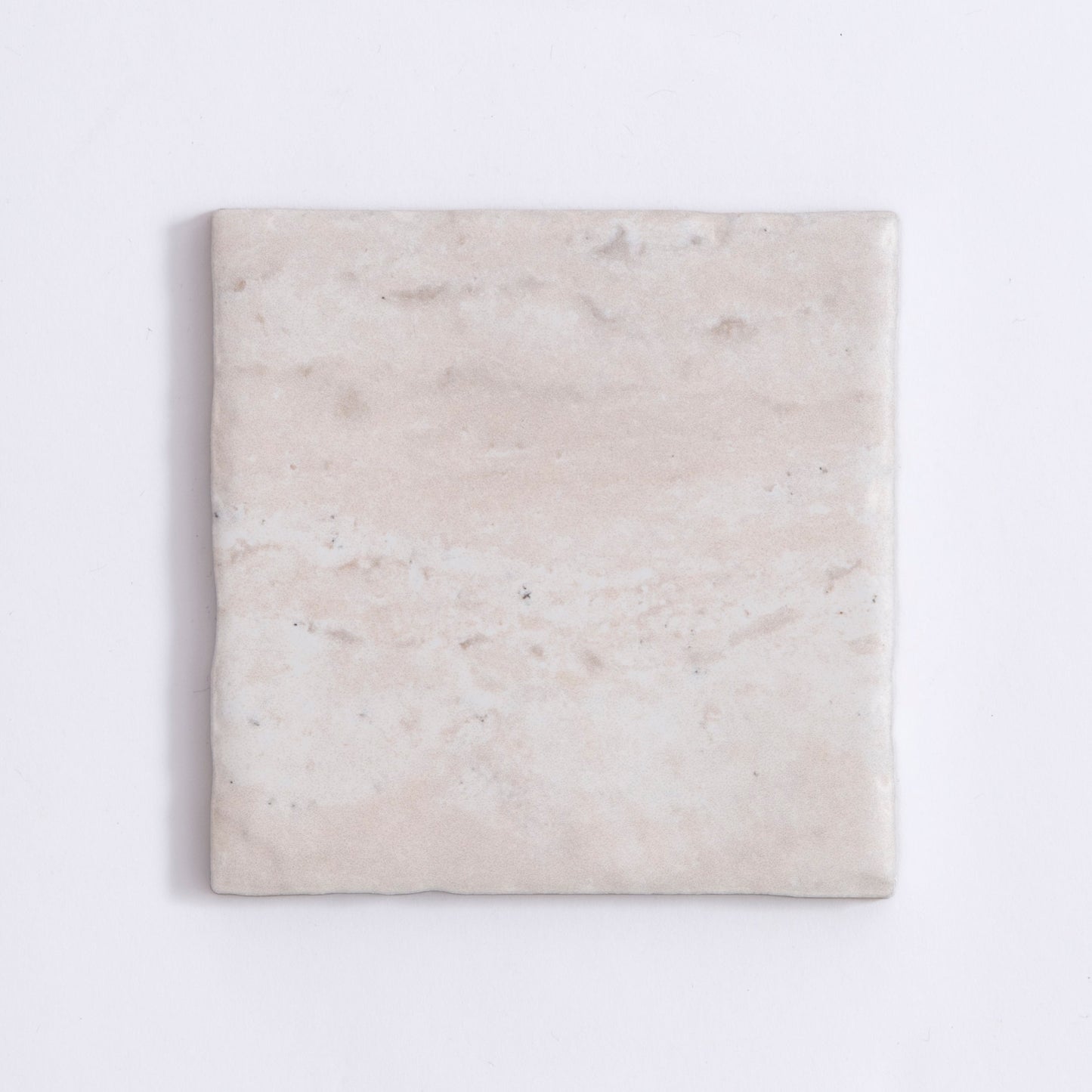 The Tosca Travertine is a square, light beige ceramic tile with a subtle marbled texture and slightly uneven surface.