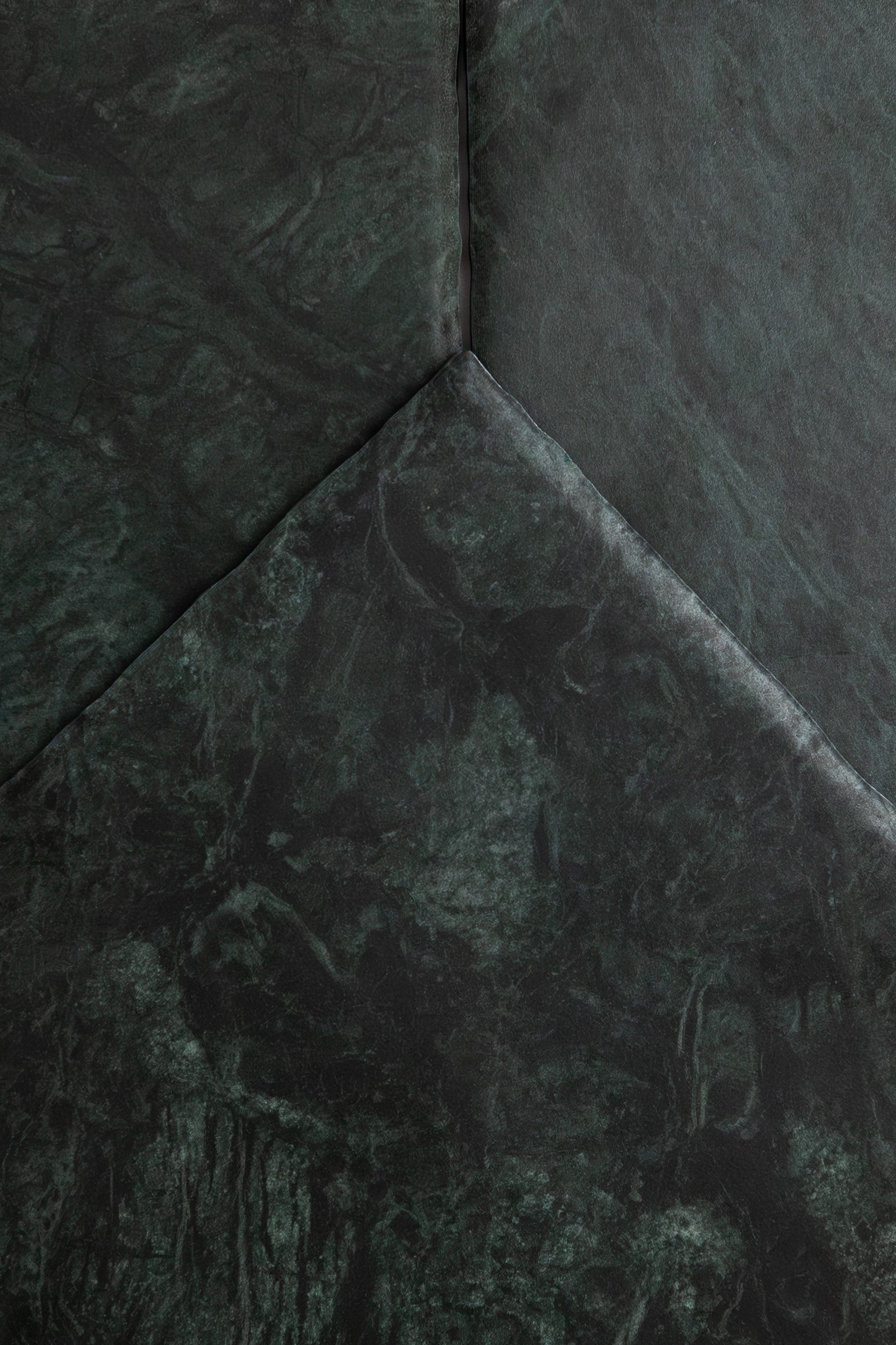 Verde Tia by Tosca features dark green textured surfaces with sharp angles and subtle marbling for a geometric look.