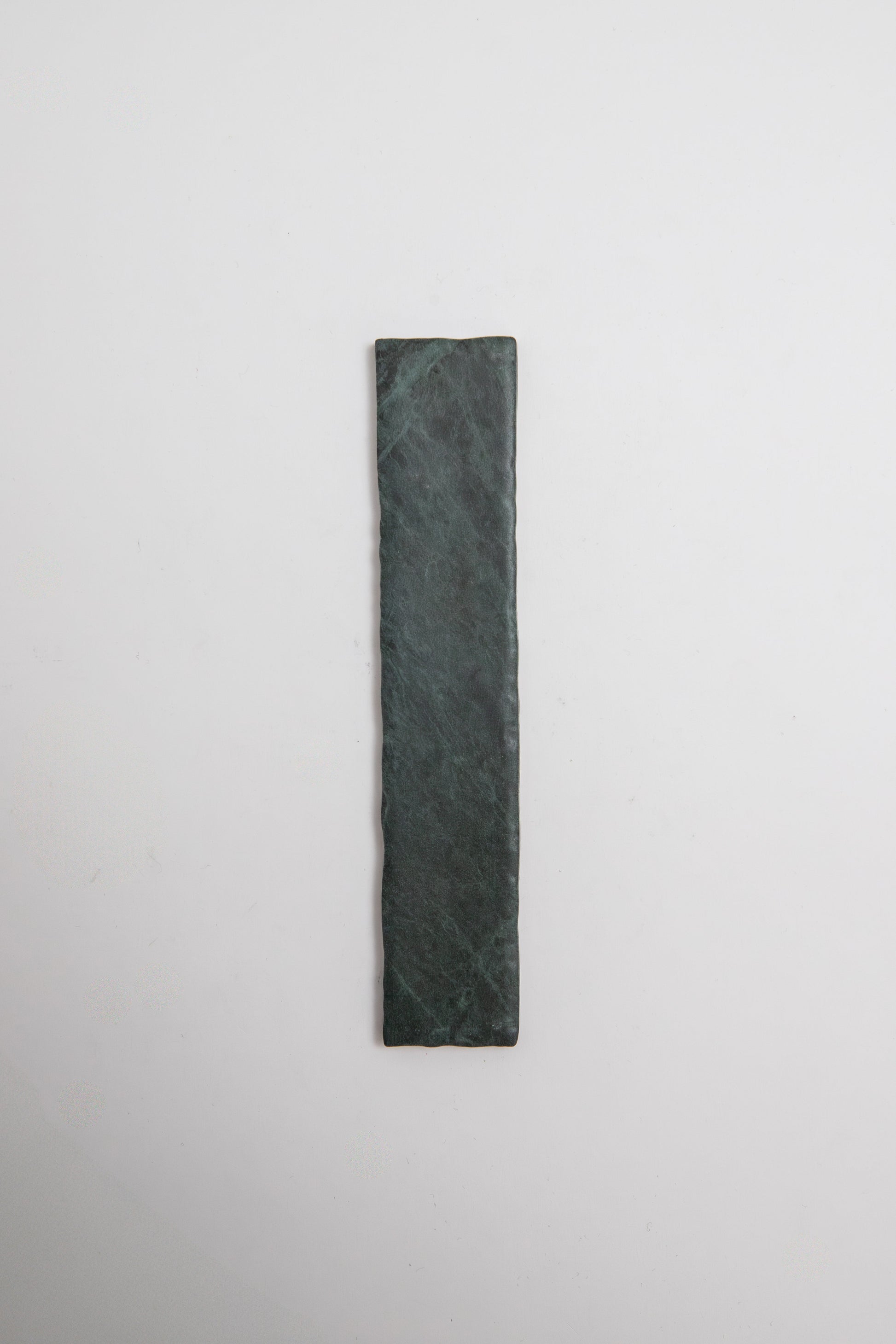 A rectangular Verde Tia marble sample by Tosca, in dark green, displayed on a plain white background.