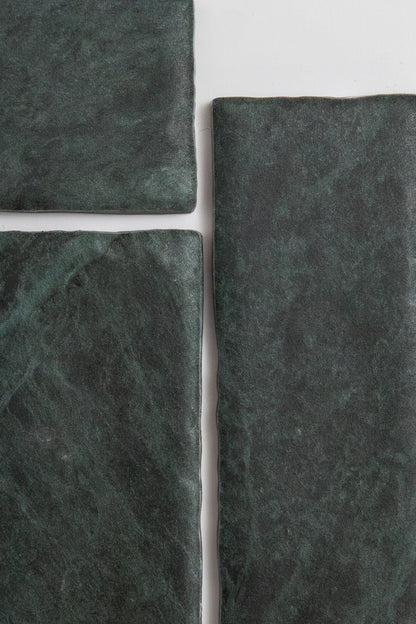 Four Verde Tia tiles by Tosca, dark green and rectangular with a rough texture, arranged on a white background.