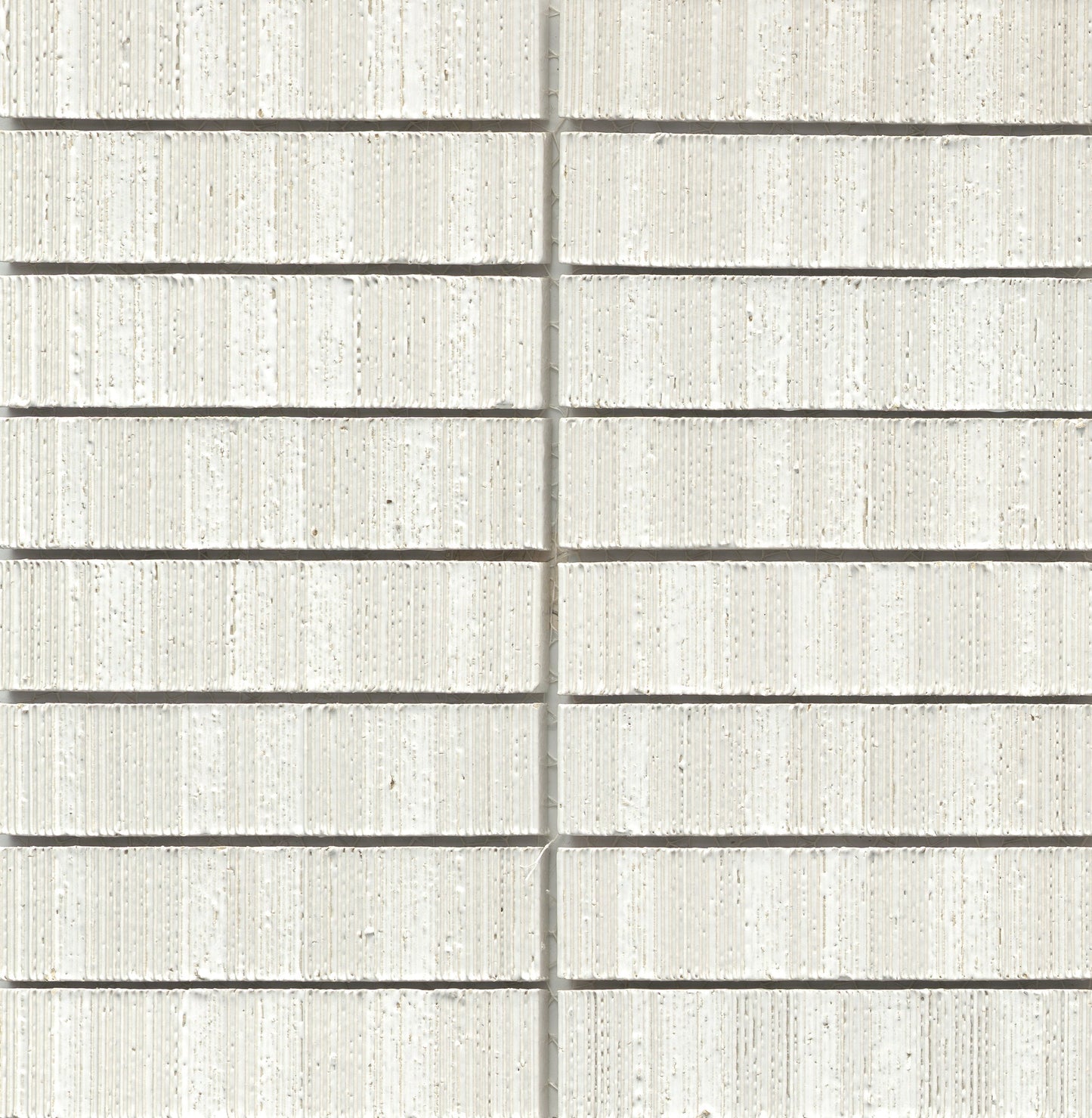 Close-up of White - Newtro - Sample brick wall by New York Cement Tile with rows, vertical seam, and geometric pattern.