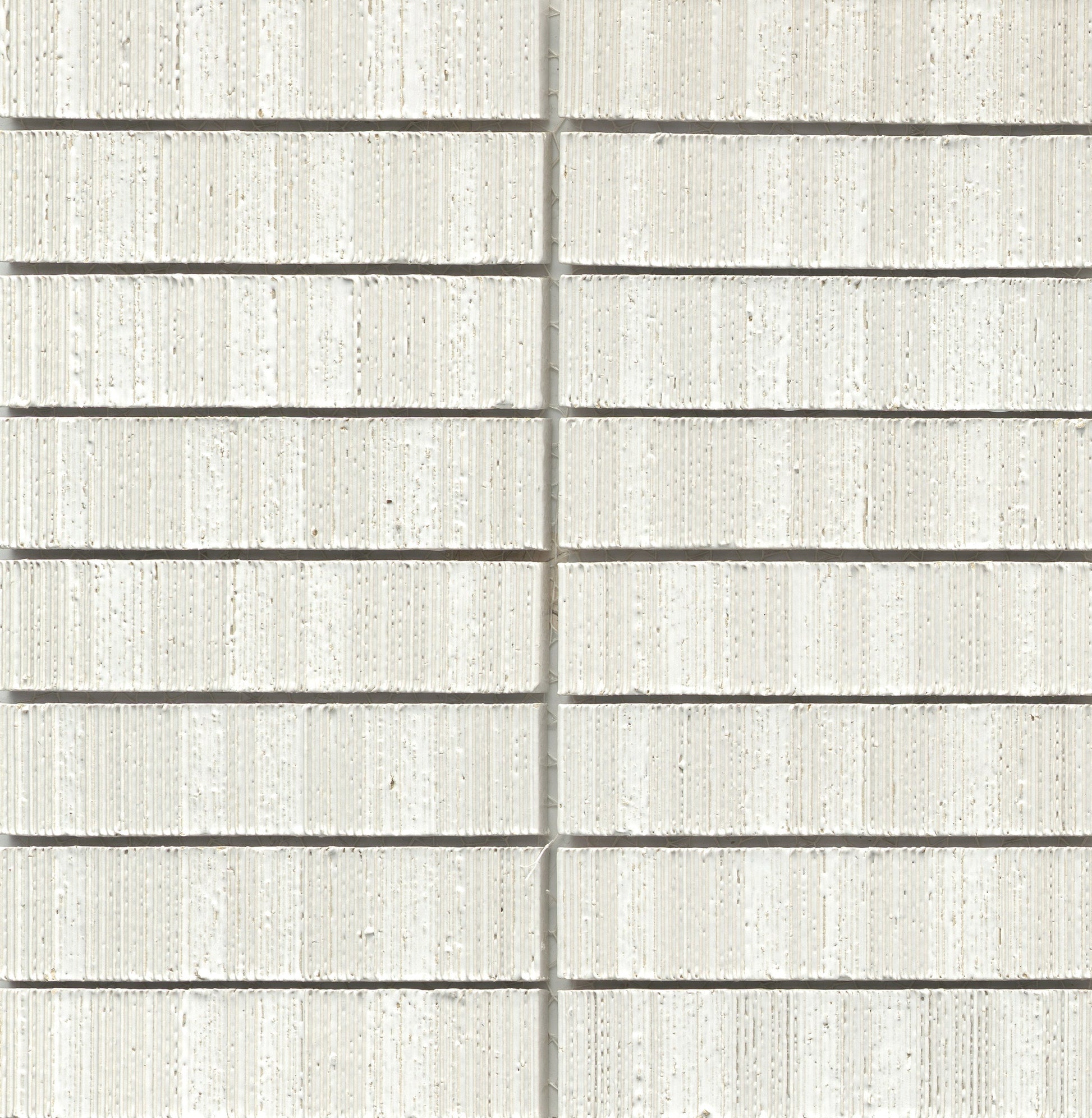 Close-up of White - Newtro - Sample brick wall by New York Cement Tile with rows, vertical seam, and geometric pattern.